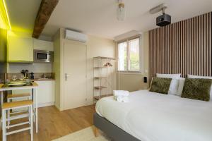 a bedroom with a large bed and a kitchen at Air Nomad • Stockholm in Valenciennes