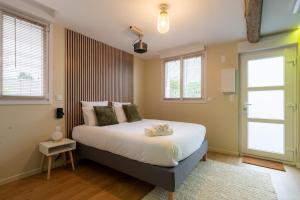 a bedroom with a bed and two windows at Air Nomad • Stockholm in Valenciennes +6 photos