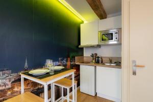 a kitchen with a table and a microwave at Air Nomad • Stockholm in Valenciennes