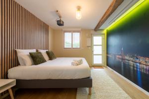 a bedroom with a bed with a green accent wall at Air Nomad • Stockholm in Valenciennes