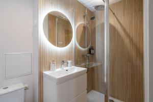 a white bathroom with a sink and a shower at Air Nomad • Stockholm in Valenciennes