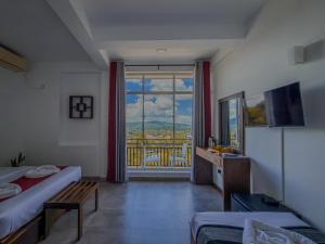 a room with two beds and a window with a view at Red Chillies Nature Inn in Kandy