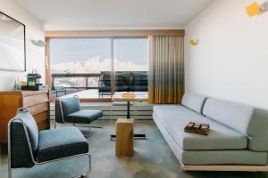 a living room with a couch and two chairs at La Cachette, Friendly Hotel & Spa in Arc 1600