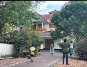 a group of people standing in front of a house at Well maintained Calm atmosphere in Putuppalli