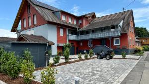 a house with a car parked in front of it at Heimbi Home No 2 I 4-5 Personen I Familienfreundlich I Balkon I Nähe EuropaPark I Parkplatz I E Ladestation in Schwanau +49 photos