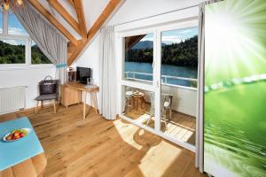 a room with a large window with a view of the water at Seehotel Sparer in Appiano sulla Strada del Vino