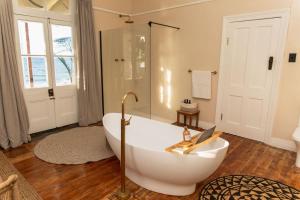 a bathroom with a white tub and a window at Stoep By Ideas Cartel in Kalk Bay +129 photos