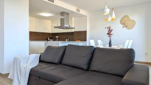 a living room with a couch and a kitchen at ALLONBAY spa & beach house in Villajoyosa