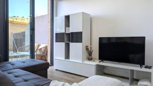 a living room with a television on a white entertainment center at ALLONBAY spa & beach house in Villajoyosa