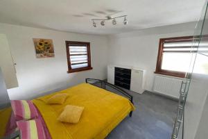 a bedroom with a bed with a yellow blanket at Apartma Devs in Kranjska Gora