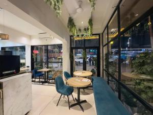a restaurant with two tables and chairs and windows at Royal Palm Inn in Jāmb