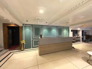 a lobby with green walls and a reception desk at Royal Palm Inn in Jāmb