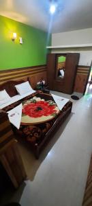 a room with a bed with a flower on it at Padayappa Residency in Kodaikānāl
