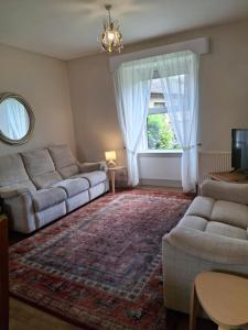 a living room with two couches and a window at Aberlour Cottages - Bolthole & Retreat in Aberlour