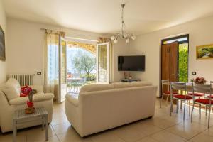 a living room with a white couch and a table at Apartment Maya - Tremezzina in Tremezzo