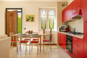 a kitchen with red cabinets and a table and chairs at Apartment Maya - Tremezzina in Tremezzo