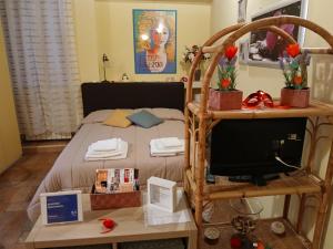 a bedroom with a bed with a television and a table at GRAZIOSO Appartamento in Spoleto