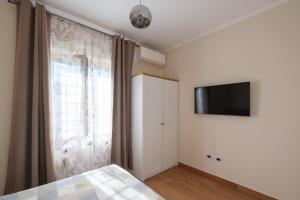 a bedroom with a bed and a television on the wall at Gioia apartment in Sabaudia