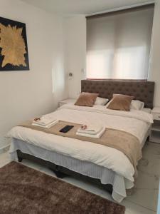 a bedroom with a large bed with white sheets and brown pillows at Apartmani B&R in Lazarevac