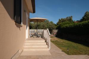 a porch with a table and an umbrella at Gioia apartment in Sabaudia