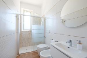 a bathroom with a toilet and a sink and a mirror at Gioia apartment in Sabaudia