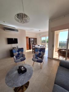 a living room with a couch and chairs and a table at ROSE VILLA - 3 BED POOL in Episkopi Limassol