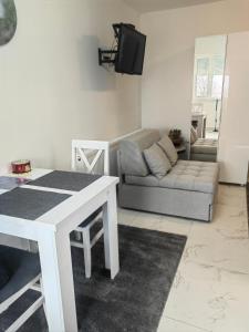 a living room with a white table and a couch at Apartmani B&R in Lazarevac