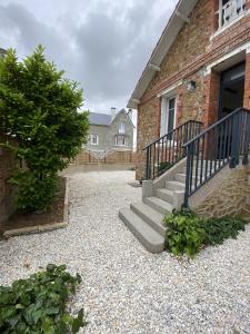 a house with a stone walkway next to a building at La Grande Mimi in Jard-sur-Mer