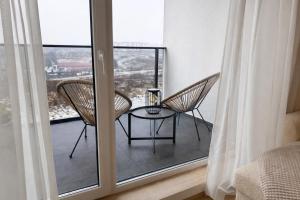 a room with two chairs and a table on a balcony at BONA Apartment in Świecie