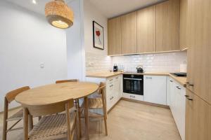 a small kitchen with a wooden table and chairs at BONA Apartment in Świecie