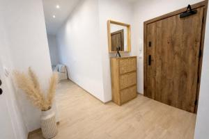 a hallway with a wooden door and a vase with a plant at BONA Apartment in Świecie