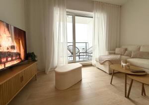 a living room with a couch and a tv and a living room with a fireplace at BONA Apartment in Świecie