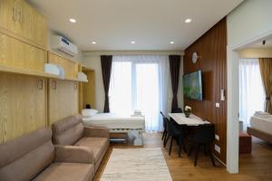 a hotel room with a couch and a bed and a desk at La Dimora Azzurra in Vlorë