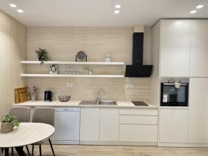 a kitchen with white cabinets and a table at La Dimora Azzurra in Vlorë +146 photos