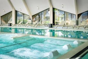a swimming pool with chairs in a building at Thalazur Carnac - Résidence in Carnac