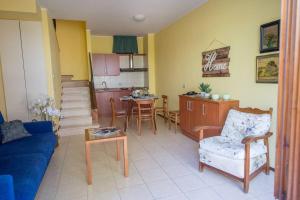 a living room with a blue couch and a kitchen at Casa Oliva borgo del Benessere delle Marche in Bargni