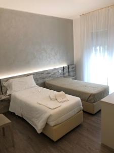 a bedroom with two beds and a window at Alloggi Al Melograno in Marcon