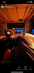 a person laying on a bed in front of a television at La Torre d' Espinalbet in Castellar del Riu