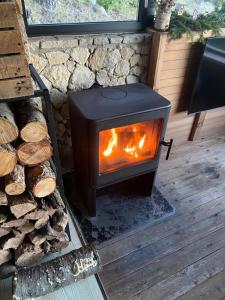 a stove in a room with a pile of logs at La Torre d' Espinalbet in Castellar del Riu