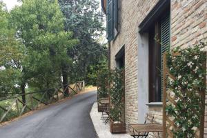 a brick building with benches on the side of a road at Casa Oliva borgo del Benessere delle Marche in Bargni