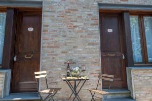 a table with two chairs and two wooden doors at Casa Oliva borgo del Benessere delle Marche in Bargni +72 photos