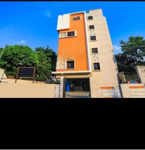 a tall building with an orange and white at Hotel Krishna in Nagpur