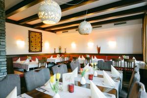 ein Esszimmer mit Tischen, Stühlen und Kronleuchtern in der Unterkunft Hotel Weiß in Munderfing