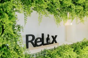 a sign for a restaurant with plants growing around it at Urban Style Victoria Boutique Hotel in Arcachon