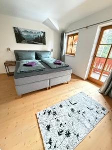 a bedroom with a bed and a rug at Ferienwohnung Leitacker im Kaiserwinkl in Rettenschöss