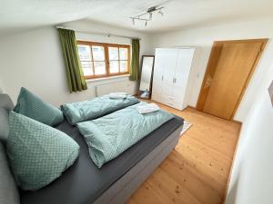 a bedroom with a bed with blue pillows on it at Ferienwohnung Leitacker im Kaiserwinkl in Rettenschöss
