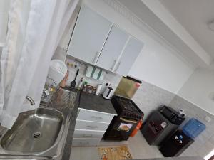 a small kitchen with a sink and a stove at Waridi Homes One-bedroom Naivegas Apartment in Naivasha