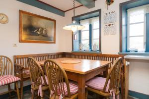 a dining room with a wooden table and chairs at Hansen Hof 1 in Tinnum +7 photos