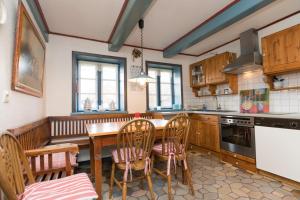 a kitchen with a wooden table and chairs in it at Hansen Hof 1 in Tinnum