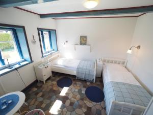 a bedroom with two beds in a room with windows at Hansen Hof 1 in Tinnum